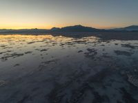 a view of an ocean during sunset in the beach area at low tide, near a beach resort