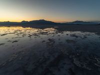 a view of an ocean during sunset in the beach area at low tide, near a beach resort