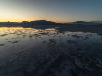 a view of an ocean during sunset in the beach area at low tide, near a beach resort