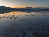 a view of an ocean during sunset in the beach area at low tide, near a beach resort