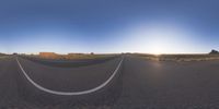 the panoramic image shows some sort of desert with rocks in the distance and on each end a long path is surrounded by grass