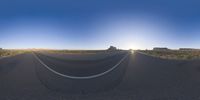 the panoramic image shows some sort of desert with rocks in the distance and on each end a long path is surrounded by grass