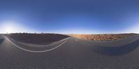 the panoramic image shows some sort of desert with rocks in the distance and on each end a long path is surrounded by grass