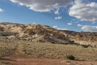 a landscape image of a lone man and road going through the desert with rolling clouds