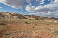 a landscape image of a lone man and road going through the desert with rolling clouds