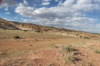 a landscape image of a lone man and road going through the desert with rolling clouds