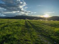 a lone country road is in the countryside area with mountains on both sides and barbed fence between the two sides