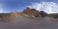 a view from a fish eye lens, of the red rocks and blue sky above