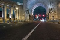 there is a street and road next to the arch of triumph in this city at night