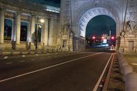 there is a street and road next to the arch of triumph in this city at night