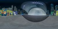 a fish eye photo of the city by night looking at the reflection of an object