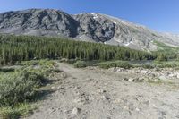 a small campground sits on the side of a mountain near a river, surrounded by some tall rocks