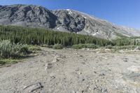 a small campground sits on the side of a mountain near a river, surrounded by some tall rocks