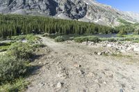 a small campground sits on the side of a mountain near a river, surrounded by some tall rocks