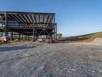 a picture of a building being built on a field near a forest in the background