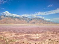 the desert landscape is pink as well as the mountains that make up the area are white