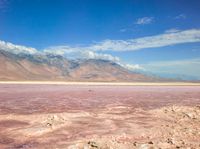 the desert landscape is pink as well as the mountains that make up the area are white