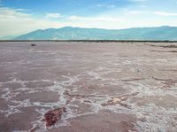 the pink substance is very reddish near the mountain range in the distance on the vast landscape