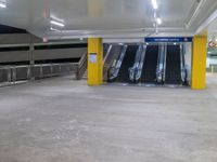 a parking garage with the two escalators leading in the direction of the floor