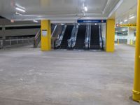 a parking garage with the two escalators leading in the direction of the floor