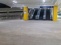 a parking garage with the two escalators leading in the direction of the floor