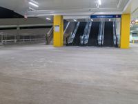 a parking garage with the two escalators leading in the direction of the floor