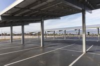 a parking lot with a row of large parking bays under it and sky in the background