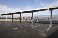 parking lot covered in a long line of poles with a table set up beneath the canopy