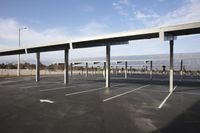 parking lot covered in a long line of poles with a table set up beneath the canopy