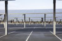 a parking lot with rows of solar panels mounted on the side of the building with street light