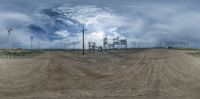 a photo taken while using a 3d fisheye effect on a dirt road with power lines in the background