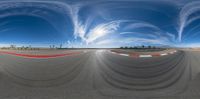 a 360 - view picture shows the speed on a track, and some swirling clouds in the sky