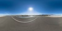 this 360 - fish eye panoramic photo shows a racetrack with cars turning into the lane