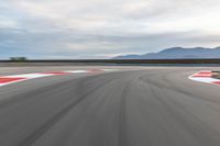 a photo of a dirt race track with sun setting in the distance of the track