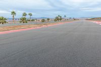 a photo of a dirt race track with sun setting in the distance of the track