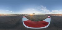 a 360 lens with red and white paint is shown near some palm trees and desert area