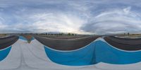 a view looking up at a sky with several curves around it in different directions, the same angle, with many clouds and a single person in the sky