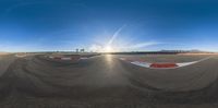 view of empty track as viewed from camera in perspective mirror lens with blue sky and mountains in the background