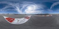 a panoramic view of the track with clouds and water in the background, and two people skating near each other