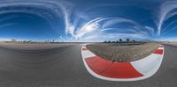 a panoramic image of the race track at an intersection with a curve and some clouds in the sky