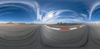 a 360 - lens image of a track taken on the street below with blue skies in the background