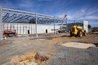 the construction area of this modern steel building in an open area with rubble and other equipment