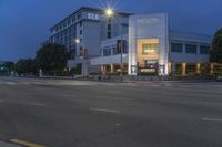 a large gray building with an open sign above it in the middle of the night