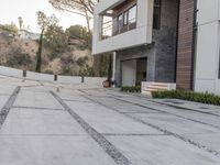 the exterior and landscape of a modern house in los angeles, california with stone and wood