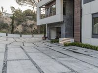 the exterior and landscape of a modern house in los angeles, california with stone and wood