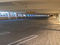 there is a large empty parking garage in a building with no people around the car port