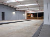 a very large room has some lights and concrete in it, as well as a concrete ramp