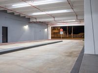 a very large room has some lights and concrete in it, as well as a concrete ramp