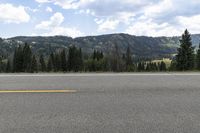 an asphalt road with trees and mountains in the background for an article on how to use asphalt for rvs