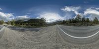 a 360 - degree image shows the mountain and road from a street corner, showing the winding curve